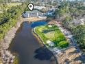 An aerial view showcases the property's proximity to a pond, golf course, and lush surroundings at 131 Greenside Villas Dr. # B10, Little River, SC 29566