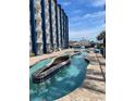 Beautiful outdoor pool area with a lazy river feature, surrounded by blue accents and sunny skies at 201 77Th Ave. N # 420, Myrtle Beach, SC 29577