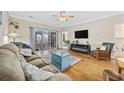 Cozy living room featuring hardwood floors, a comfortable sofa, and sliding glass doors to an outdoor patio at 4142 Hibiscus Dr. # 103, Little River, SC 29566