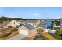 Charming tan home with gray roof and white trim, nestled on a waterfront lot at 4387 Heartwood Ln., Myrtle Beach, SC 29579