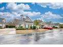 View of a brick and siding house with green shutters and a well-manicured front yard in a residential neighborhood at 440 Woodpecker Ln. # A, Murrells Inlet, SC 29576