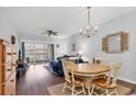 Cozy living room and dining area with hardwood floors, chandelier, and sliding door to balcony at 4449 Turtle Ln. # 3-C, Little River, SC 29566