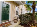 Inviting front porch featuring a decorative welcome mat, potted plants and a tropical palm tree at 446 Deerfield Links Dr., Surfside Beach, SC 29575