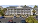 Three-story condominium building with balconies and a well-maintained parking area and landscaped grounds at 5060 Windsor Green Way # 304, Myrtle Beach, SC 29579