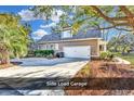 Home with a large side entry two-car garage and a spacious driveway at 52 Olde Canal Loop, Pawleys Island, SC 29585