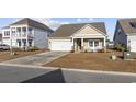 Inviting home exterior with a concrete driveway, attached garage, and manicured front lawn at 521 Harbison Circle, Myrtle Beach, SC 29579