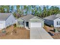 An aerial view of a cozy green home with a driveway, surrounded by lush trees and neighboring houses at 609 Gryffindor Dr., Longs, SC 29568