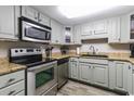 Galley kitchen with stainless steel appliances, light wood cabinets, and wood laminate flooring at 7603 N Ocean Blvd. # 4E, Myrtle Beach, SC 29572