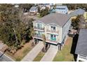 A captivating aerial view showcasing this raised beach home with its expansive property and neighborhood at 124 B Vista Dr., Murrells Inlet, SC 29576