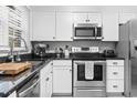 Modern kitchen featuring stainless steel appliances, white cabinets, and sleek black countertops at 1409 Highway 15 # 4, Myrtle Beach, SC 29577