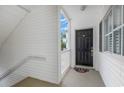 Front door entry featuring tile flooring, white siding, storm door, and Giants welcome mat at 1529 Lanterns Rest Dr. # 201, Myrtle Beach, SC 29579