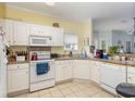 Well-lit kitchen with white cabinets, granite countertops, and modern appliances at 1529 Lanterns Rest Dr. # 201, Myrtle Beach, SC 29579