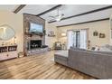 Cozy living room with brick fireplace, wood floors, ceiling beams, and natural light at 1586 Bridgebrook Ln., Conway, SC 29527