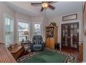 Cozy living room boasts natural light from many windows, complemented by a comfortable chair and beautiful decor at 1796 Fairwinds Dr., Longs, SC 29568