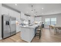 Bright kitchen with white cabinets, stainless steel appliances, large island, and hardwood floors at 2341 Hazel Way, Longs, SC 29568