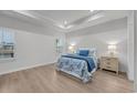 Main bedroom with a tray ceiling, hardwood floors, bright windows, and neutral paint at 2341 Hazel Way, Longs, SC 29568