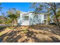 Side view of a light blue home with a cozy balcony and lush green surroundings at 301 Lumbee Circle, Pawleys Island, SC 29585