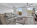 Living room boasts comfortable sofas, modern ceiling fans, and sliding doors leading to a private balcony at 423 Parker Dr. # 306, Pawleys Island, SC 29585