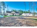 Expansive backyard view showcasing the home's exterior, lush greenery, and a detached building at 477 Cane Branch Rd., Loris, SC 29569