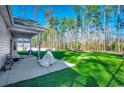 Green backyard featuring a covered patio area, a large lawn, and mature trees providing privacy at 477 Cane Branch Rd., Loris, SC 29569