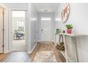 Inviting hallway with wood-look flooring, neutral paint, stylish decor, and a glimpse of a bright office space at 616 Choctaw Dr., Conway, SC 29526