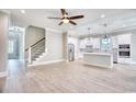 Open-concept living room with wood flooring, staircase, and kitchen featuring white cabinets at 641 Waterbridge Blvd., Myrtle Beach, SC 29579
