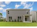 View of the home's siding, backyard and sliding glass door to covered porch at 692 Wallace Dr., Little River, SC 29566