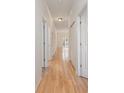 Bright hallway featuring light hardwood floors and white trim leading to a bright, airy living space at 750 Charter Dr. # E-2, Longs, SC 29568