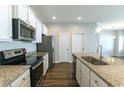 Modern kitchen features white cabinets, stainless steel appliances, granite countertops, and a kitchen island at 92 Costa Ct., Pawleys Island, SC 29585