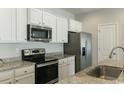 Modern kitchen features white cabinets, stainless steel appliances, and granite countertops at 92 Costa Ct., Pawleys Island, SC 29585