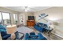 Cozy living room with plush blue seating, nautical decor, and balcony access at 9994 Beach Club Dr. # 2408, Myrtle Beach, SC 29572