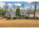 A well-manicured lawn frames this home's rear, complete with mature trees, shrubs and a bench at 1 Sun Ct., Carolina Shores, NC 28467