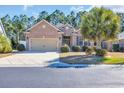Single-story brick house featuring a two-car garage, well-manicured lawn, and mature trees, creating a welcoming curb appeal at 110 Summerlight Dr., Murrells Inlet, SC 29576