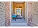 Cozy front porch with brick columns and a seating area, showcasing a welcoming entrance to the home at 110 Summerlight Dr., Murrells Inlet, SC 29576