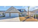 Inviting home with a stone-accented facade, two-car garage, front porch, and well-maintained lawn at 166 New Paradise Way, Myrtle Beach, SC 29588