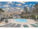 Sparkling outdoor swimming pool with lounge chairs, umbrellas, and nearby building for shade at 6015 Catalina Dr. # 734, North Myrtle Beach, SC 29582
