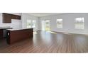 Open-concept living space with hardwood floors, island, and plenty of natural light through sliding glass doors at 703 St. Albans Loop, Conway, SC 29526