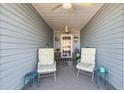 Cozy covered porch with comfortable seating, coastal decor, and blue accents at 920 Sewing Bee Pl., Little River, SC 29566