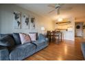 Inviting living room with hardwood floors, ceiling fan, couch, dining table, and view into the kitchen at 9501 Shore Dr. # A309, Myrtle Beach, SC 29572