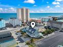 Aerial view of a coastal home, with a building and ocean in the background at 119 Sunset Dr., Murrells Inlet, SC 29576