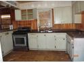 Outdated kitchen featuring white cabinets, stainless steel appliances, and a sink at 12 E Sassafras St., Andrews, SC 29510