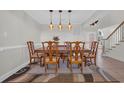 Formal dining room with a wooden table, eight chairs, decorative rug, and modern light fixtures at 128 Waterway Crossing Ct., Little River, SC 29566