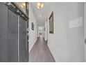 A bright hallway leads into a cozy living room with wood flooring and white walls at 1317 Captain Hooks Way, North Myrtle Beach, SC 29582