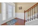 Inviting foyer with hardwood floors, white wainscoting, and a staircase with a wrought iron railing at 132 Summerlight Dr., Murrells Inlet, SC 29576