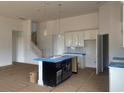 Open-concept living space with white cabinets, modern island, and staircase creating an inviting atmosphere at 147 Joyce Dr, Longs, SC 29568