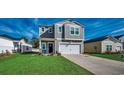 Two-story home featuring a well-maintained lawn, gray siding, and a two-car garage at 1527 Swing Bridge Way, Myrtle Beach, SC 29588