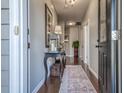 Inviting entryway featuring a console table with decor, and a patterned rug on hardwood floors at 153A Parmelee Dr. # A, Murrells Inlet, SC 29576