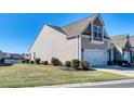 A view of the side of the house with its manicured lawn and a scenic pond in the neighborhood at 153A Parmelee Dr. # A, Murrells Inlet, SC 29576