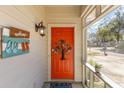 Welcoming front porch with a vibrant orange door and a charming decorative wreath at 17 Racquet Club Dr., Pawleys Island, SC 29585