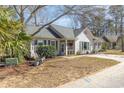 Inviting front yard featuring a cozy bench, lush greenery, and a well-manicured lawn at 17 Racquet Club Dr., Pawleys Island, SC 29585